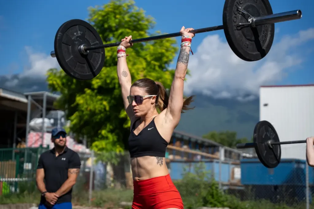 Athlète féminine soulevant une barre de crossfit à bout de bras en extérieur en Savoie